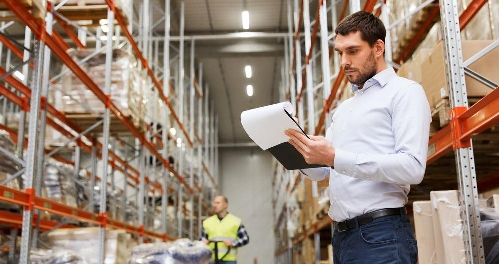 Man standing in warehouse with clip board