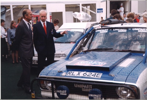 HRH Duke of Edinburgh and John Neill next to a rally car at Unipart June 1995