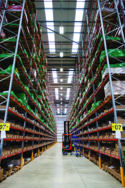 A Unipart warehouse with a forklift shown in the aisle.