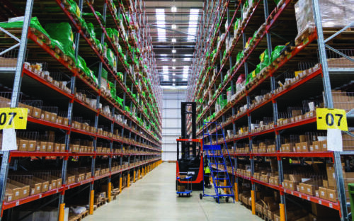 A Unipart warehouse with a forklift shown in the aisle.