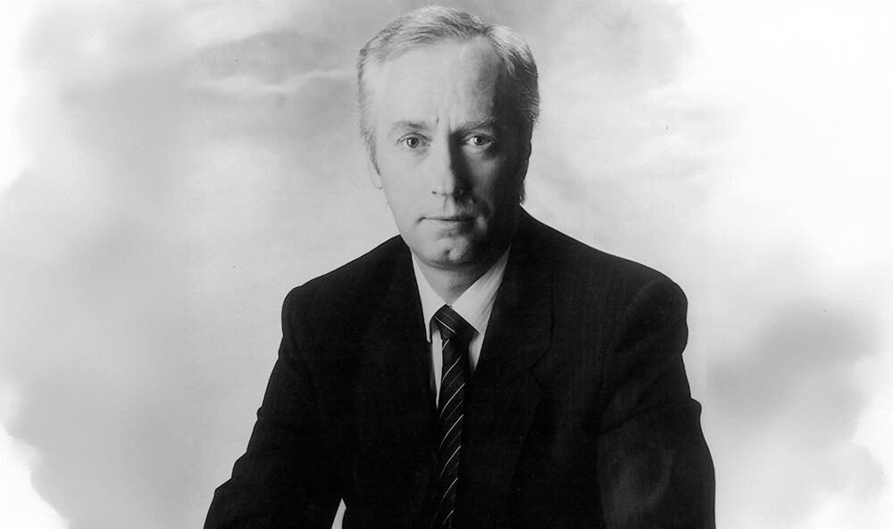 Jon Neill headshot in black and white from 1980s.