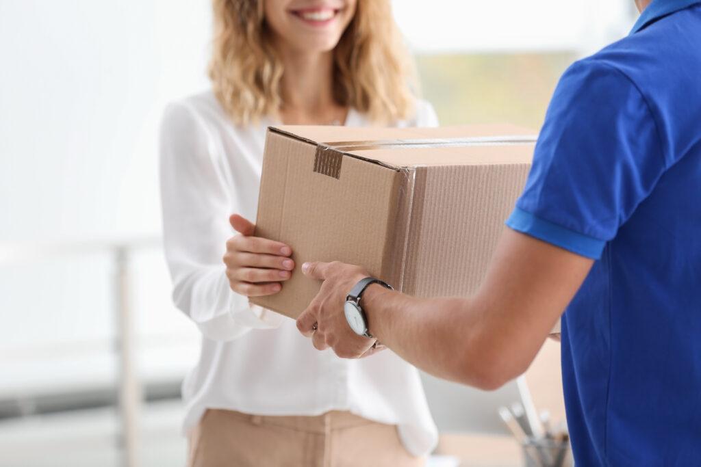 Young woman receiving parcel from courier.