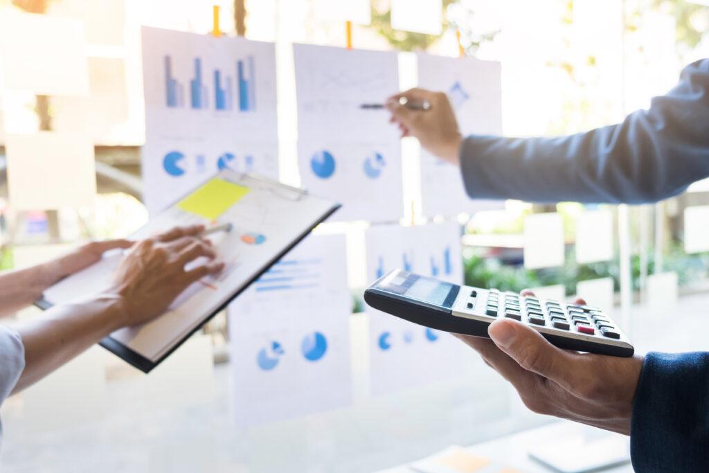 business man financial inspector and secretary making report, calculating or checking balance. Internal Revenue Service inspector checking document.