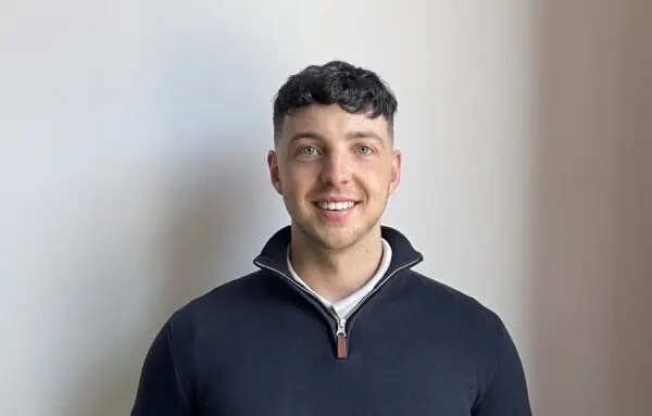 Lewis Talbot smiling at camera wearing a dark jacket.