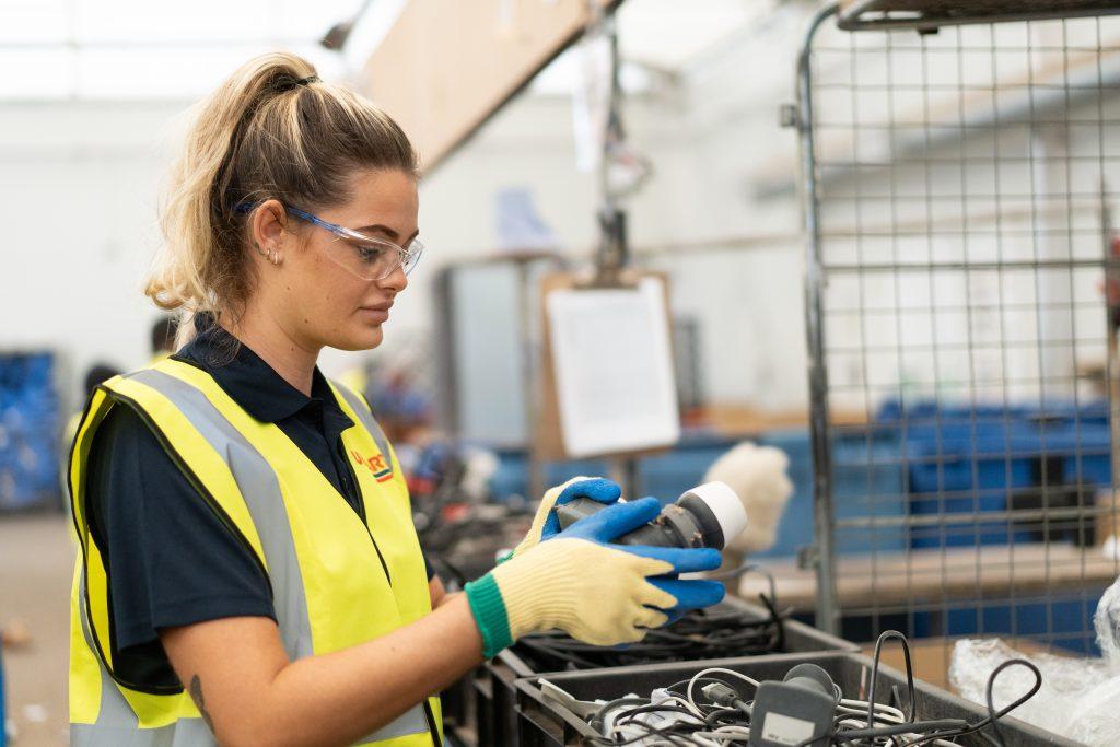 Unipart colleague in hi-vis sorting returned components.